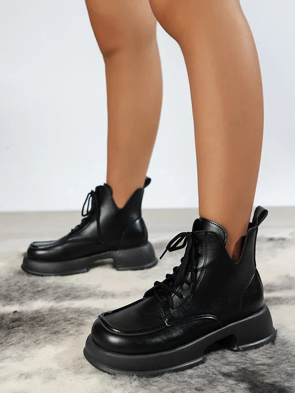 Woman wearing Skye black lace-up boots, close crop