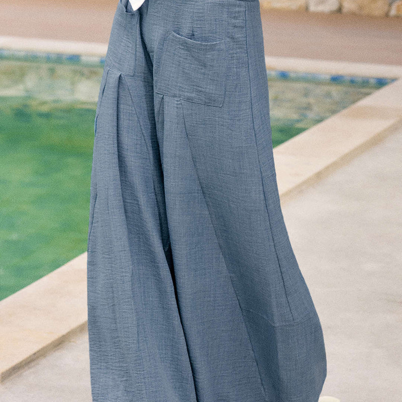 Woman wearing Vera powder blue wide leg trousers outdoors, back view