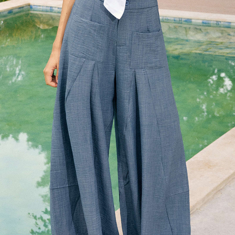 Woman wearing Vera powder blue wide leg trousers outdoors, close-up back view