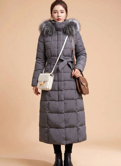 Emilia long quilted winter coat with faux fur trimmed hood in gray, front view on model