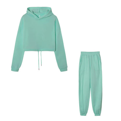 Women's green cropped hoodie and joggers set, flat lay