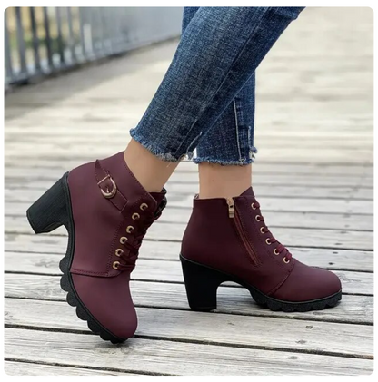 Red lace-up ankle boots with chunky tread sole, worn view