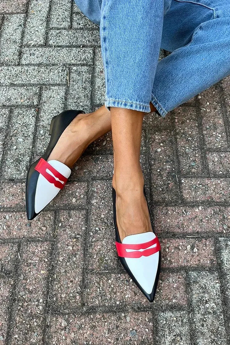 Women's black two-tone pointed toe slip-on flats, worn view