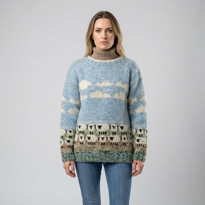Women's knit sweater with sheep, clouds and grass motif and round neck, front view